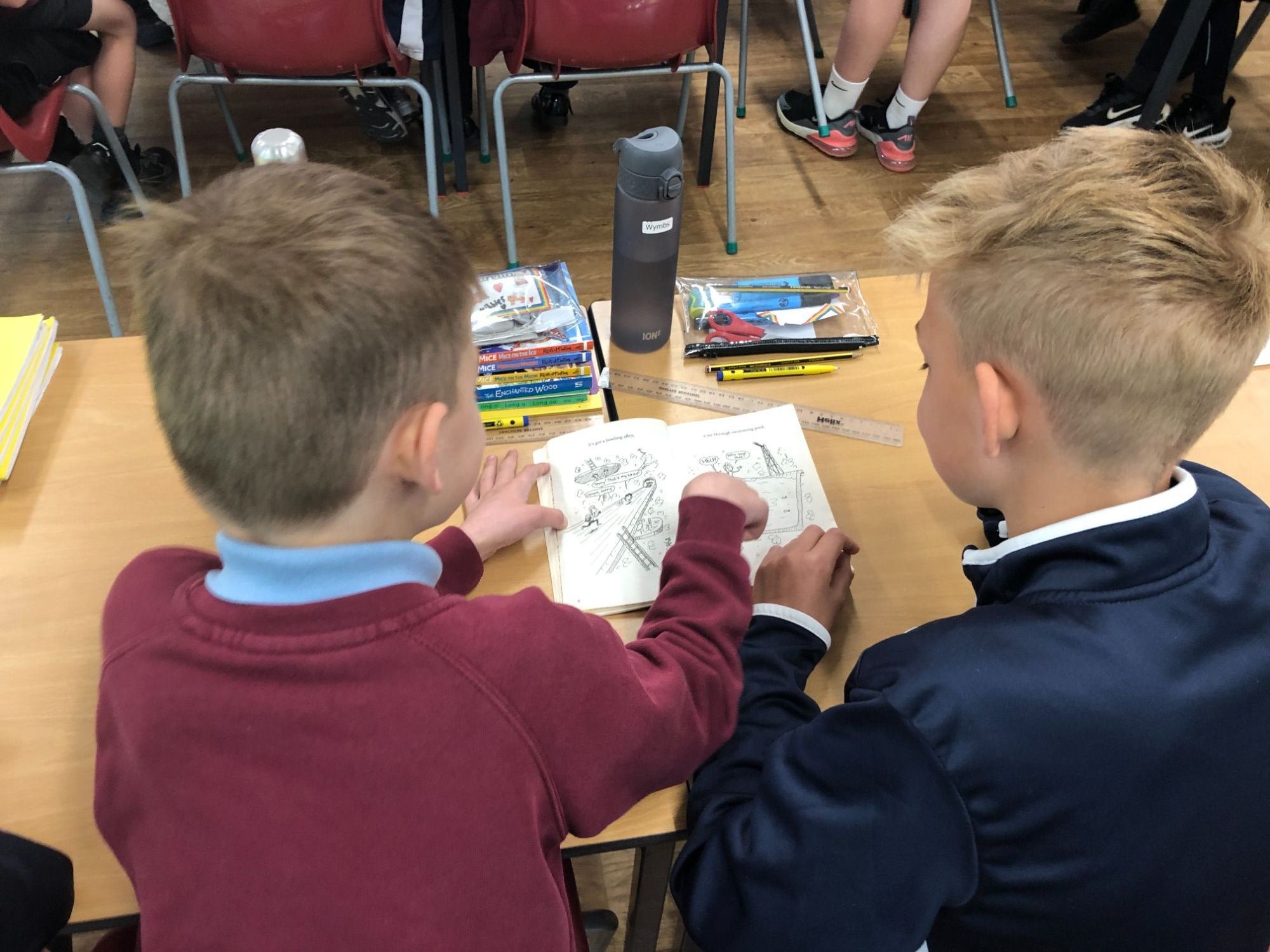 photo of two pupils reading a book together